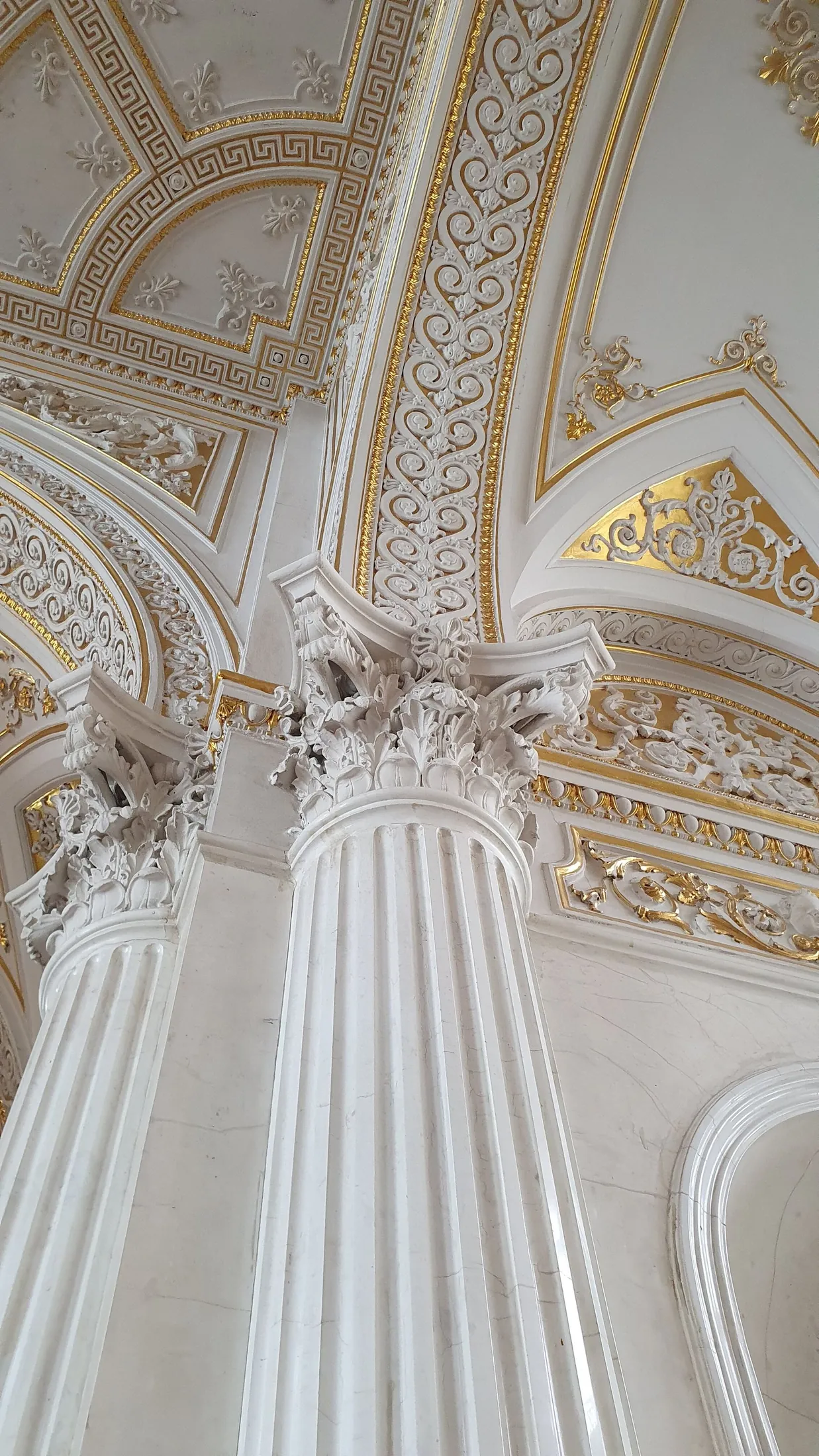 Historisch stucplafond met witte ornamenten en gouden accenten — sfeerbeeld