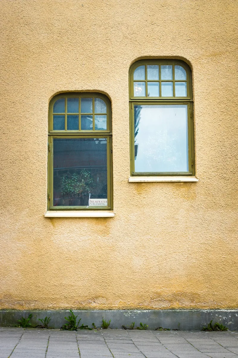 Een gele gevel met raamopeningen. — illustratieve foto