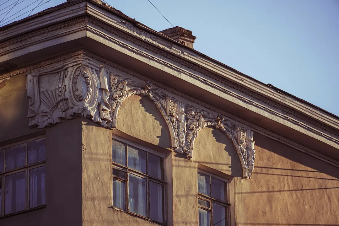 Een oudere gevel met sierlijke randdetails. — illustratieve foto