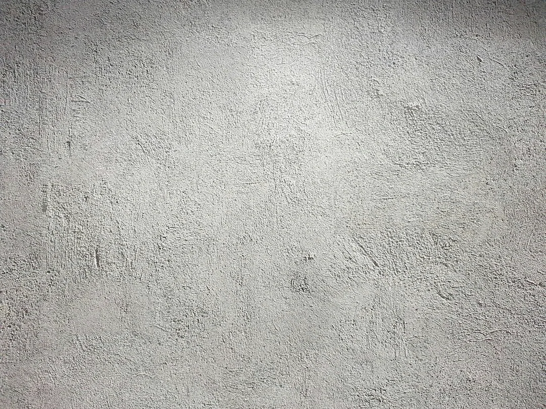 Een grijze wand met grove oppervlakteverschillen. — illustratieve foto