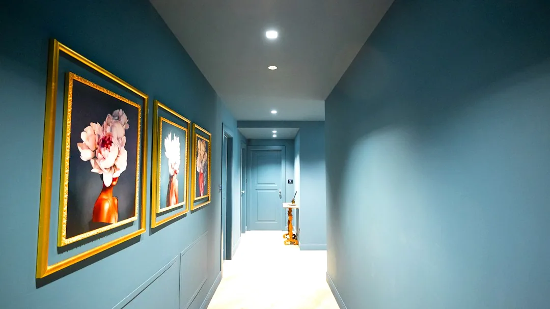 Een gang met blauwe wanden en ingelijste wanddecoratie. — illustratieve foto