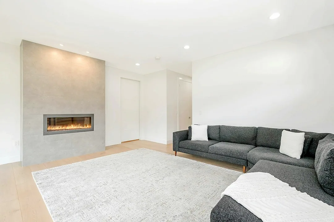 Luxury living room with smooth white walls, a clean ceiling and a fireplace.
