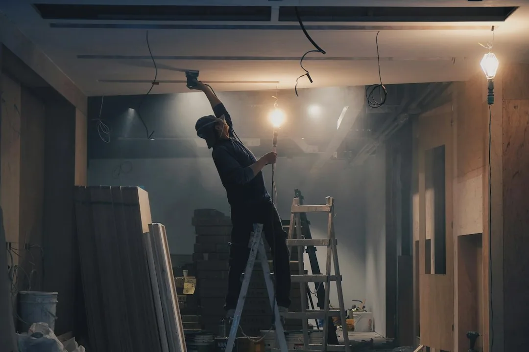 Sfeerbeeld: Een vakman werkt boven zijn hoofd tijdens een renovatie