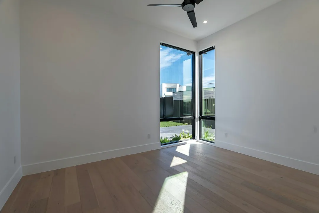 Sfeerbeeld: Een lege kamer met witte wanden en een houten vloer