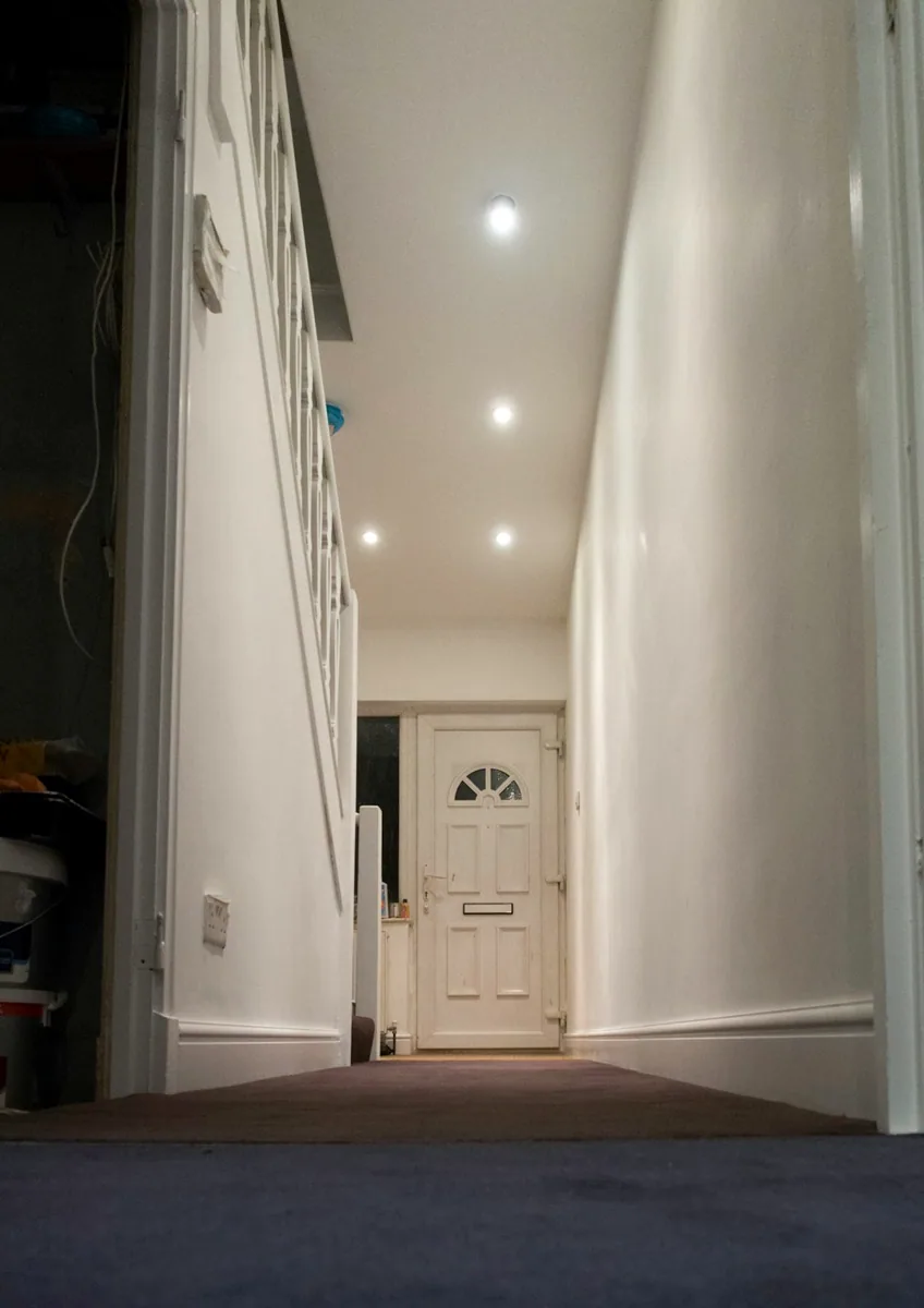 Een hal met lichte wanden en plafondspots. — illustratieve foto