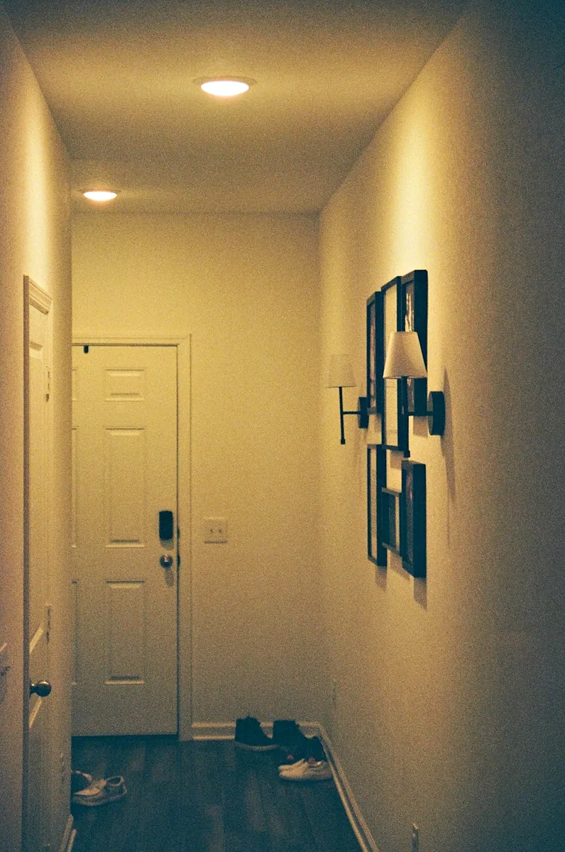 Een smalle hal met warme verlichting en lichte wanden. — illustratieve foto