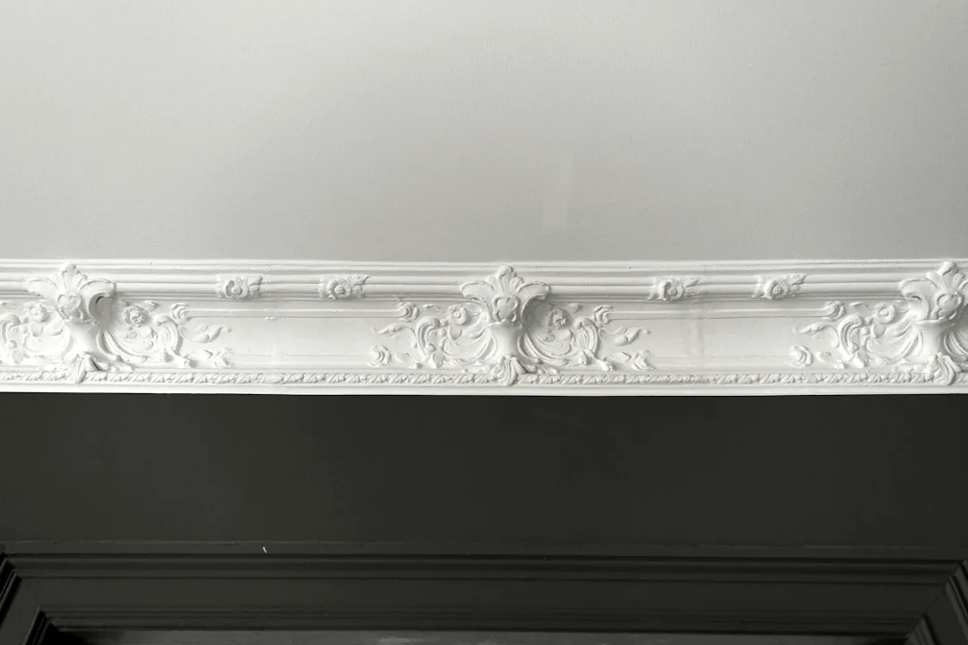 Een witte sierlijst langs de bovenzijde van een wand. — illustratieve foto